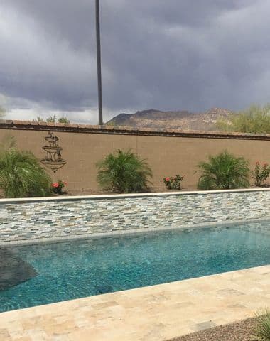 Pool with stacked-stone water wall and mountain view